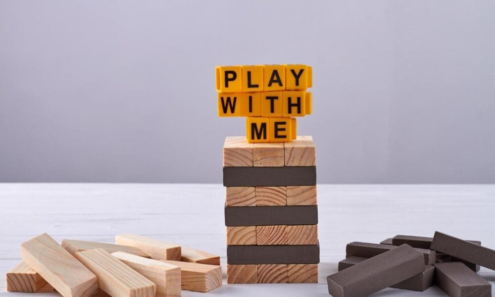 Play with me written on jenga tower