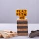 Play with me written on jenga tower