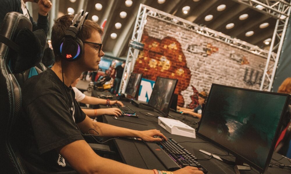 Esports player competing on a gaming PC during a live LAN tournament.