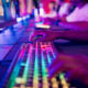 Diverse gamer group players playing competitive MOBA PvP top down view computer game on a stage. Close-up on the hands